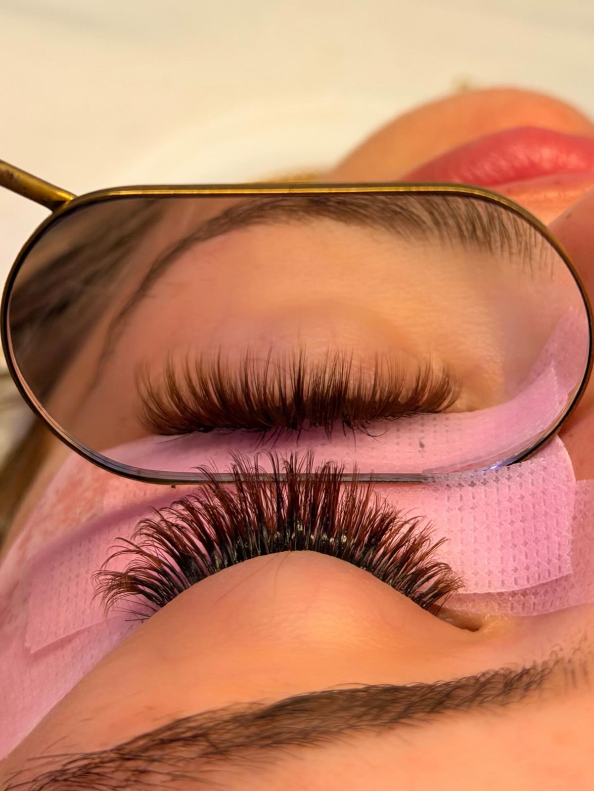Hybrid lash set seen in a gold mirror